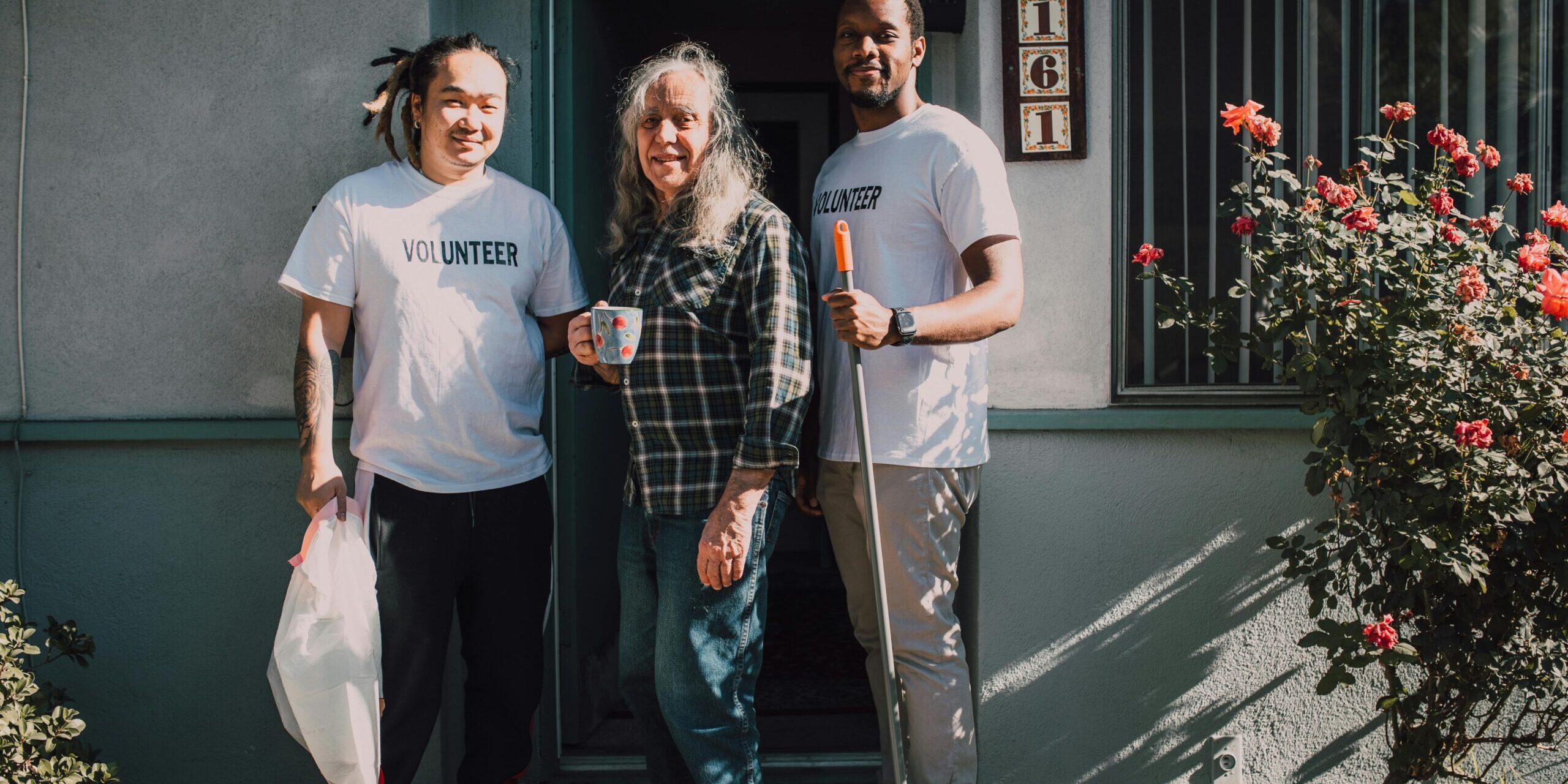 pexels-rdne-6647054 3 people standing in a doorway, 2 of them volunteers